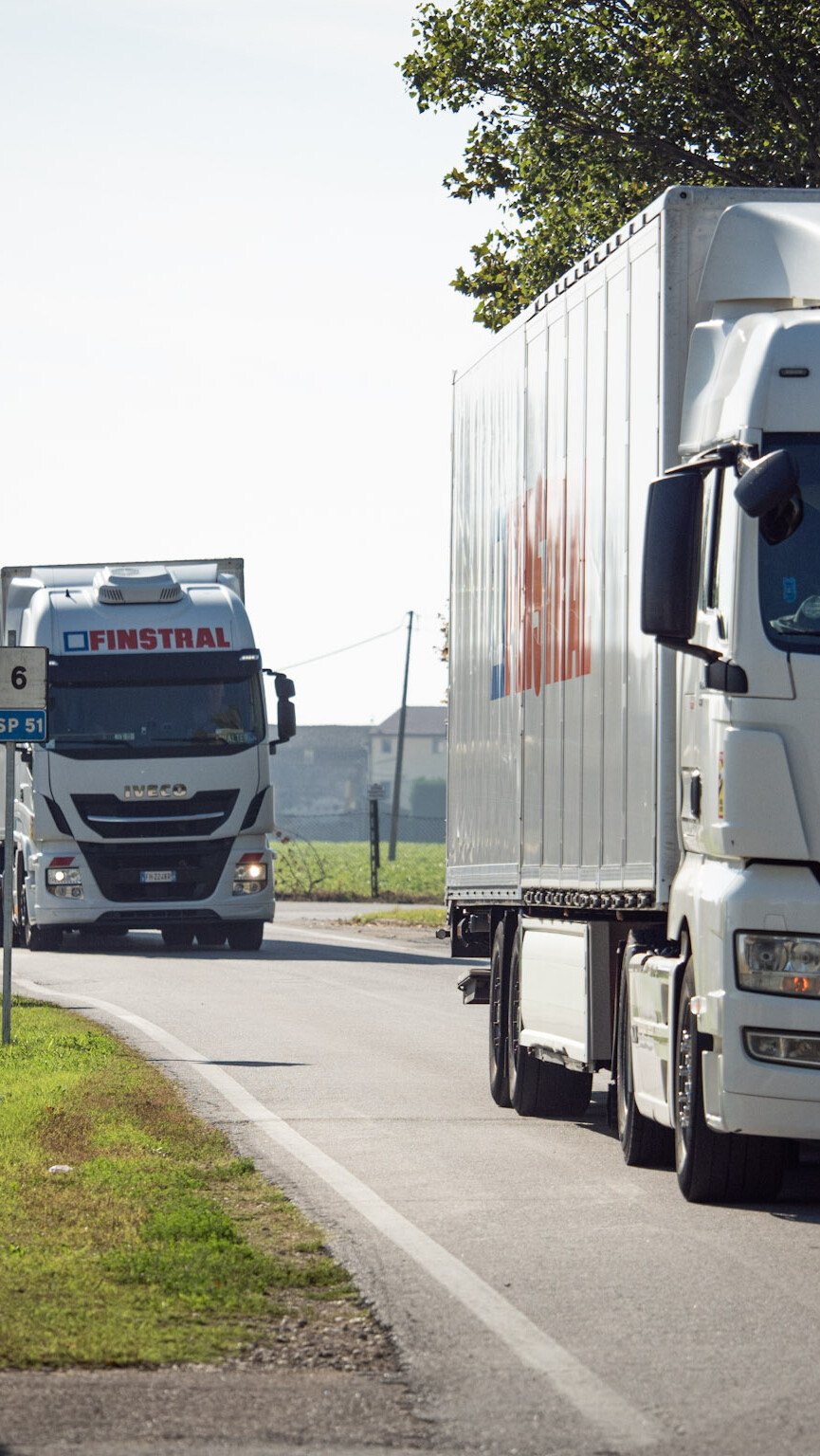 Zwei Finstral LKWs fahren auf der Straße.